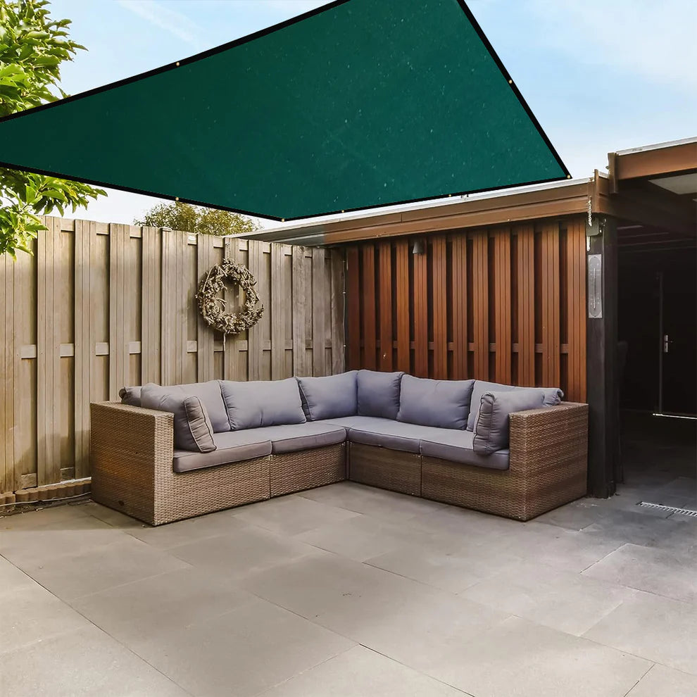 Outdoor patio with wicker sectional sofa under a green canopy