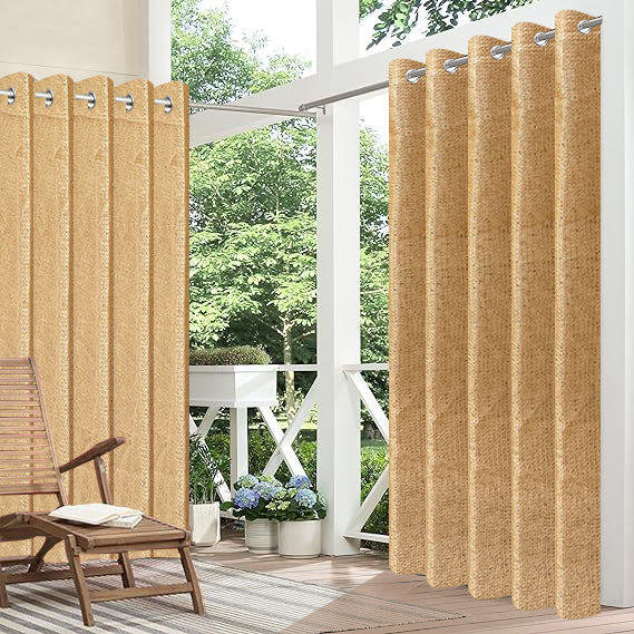 Beige outdoor curtains with grommets on a patio with a chair and plants.