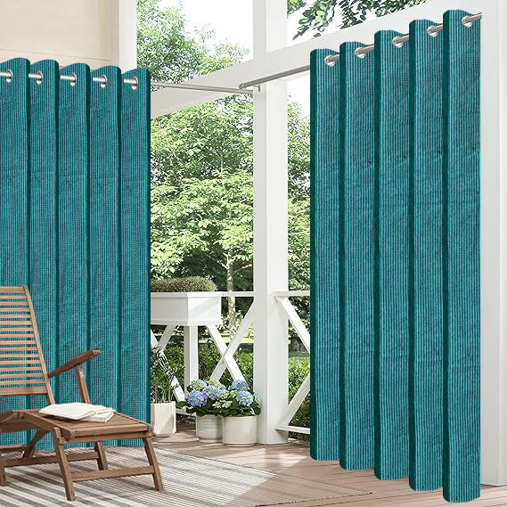 Teal outdoor curtains on a patio with a chair and plants.