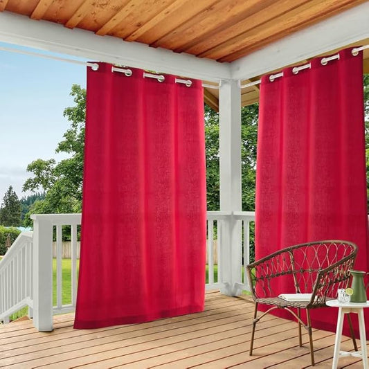 Red outdoor curtains on a wooden deck with a chair and small table.