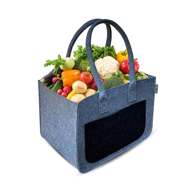 Blue tote bag filled with fresh vegetables on a white background