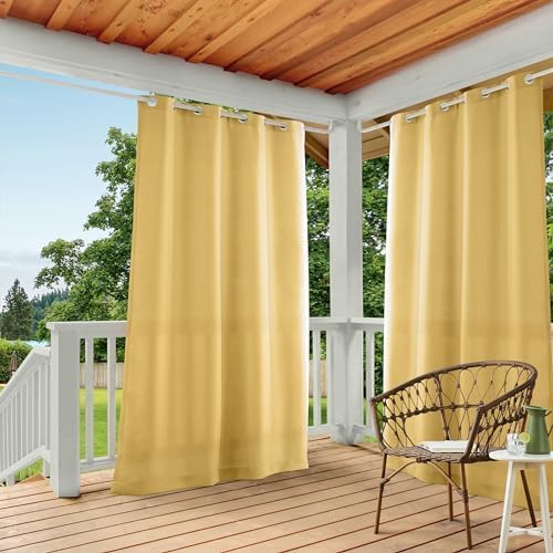 Yellow outdoor curtains on a wooden deck with a chair and table.