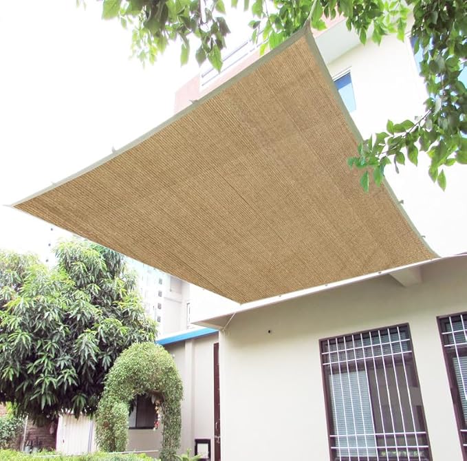 Beige outdoor canopy shade on a house with trees in the background