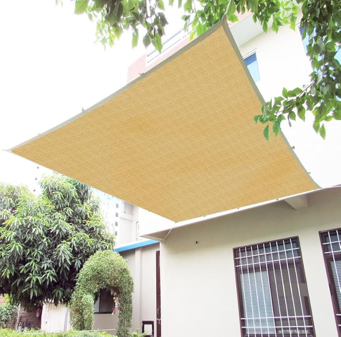 Beige sunshade on a house exterior with trees in the background