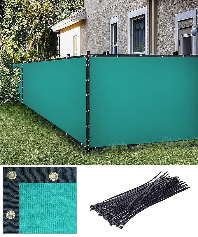 Teal privacy screen with black cables on a grassy area in front of a house.