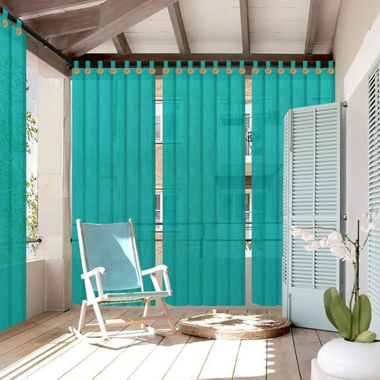 Turquoise outdoor curtains with wooden tabs on a patio with a rocking chair and potted plant.