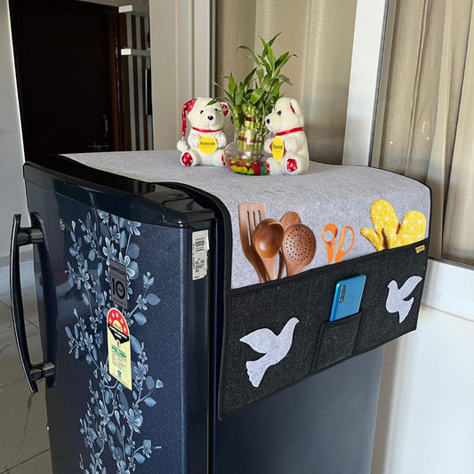 Fridge with a decorative cover and various items on top