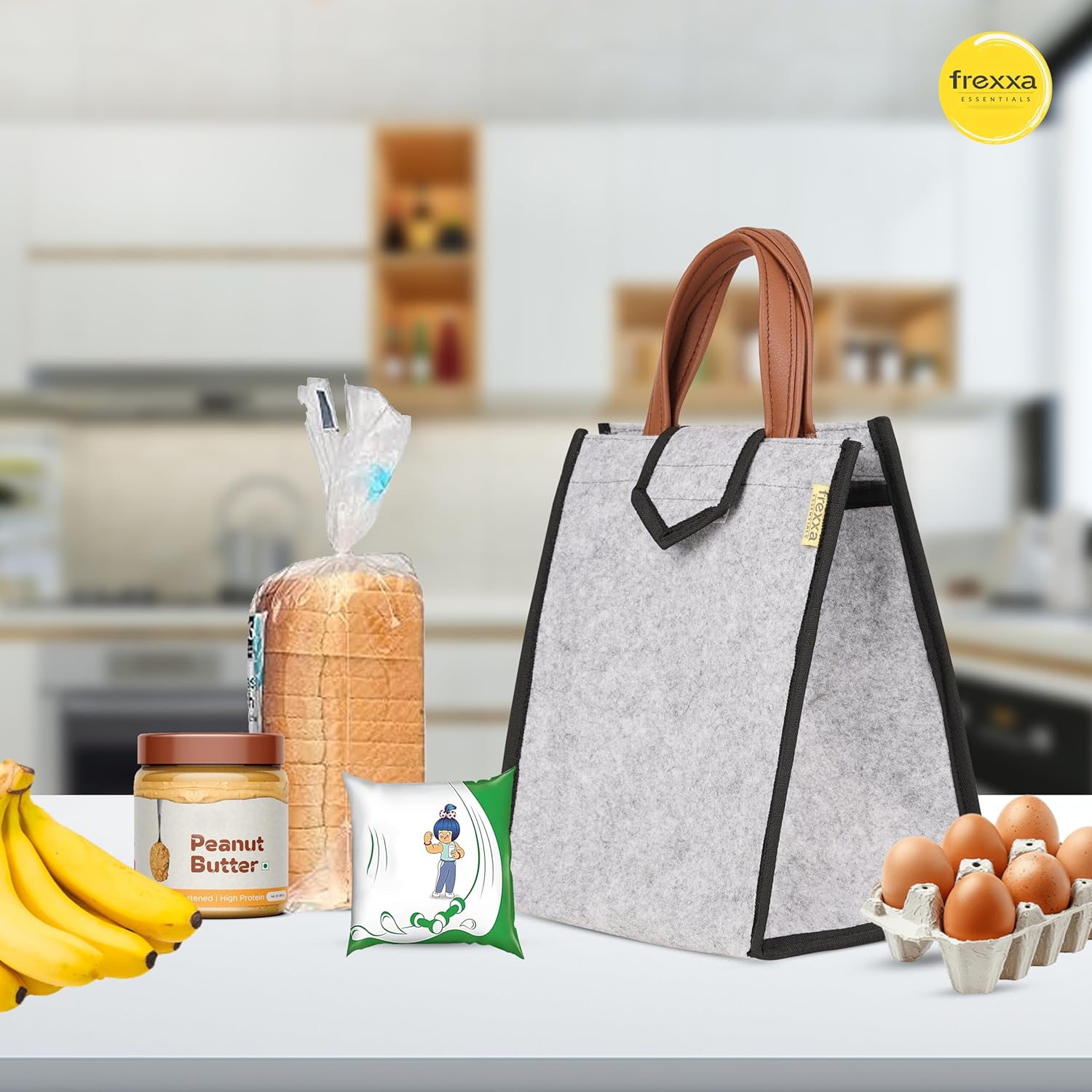 Gray lunch bag with brown handle on a kitchen counter with bread, peanut butter, bananas, and eggs.