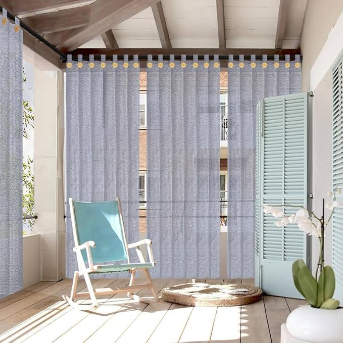 Outdoor patio with gray curtains, rocking chair, and potted plant.