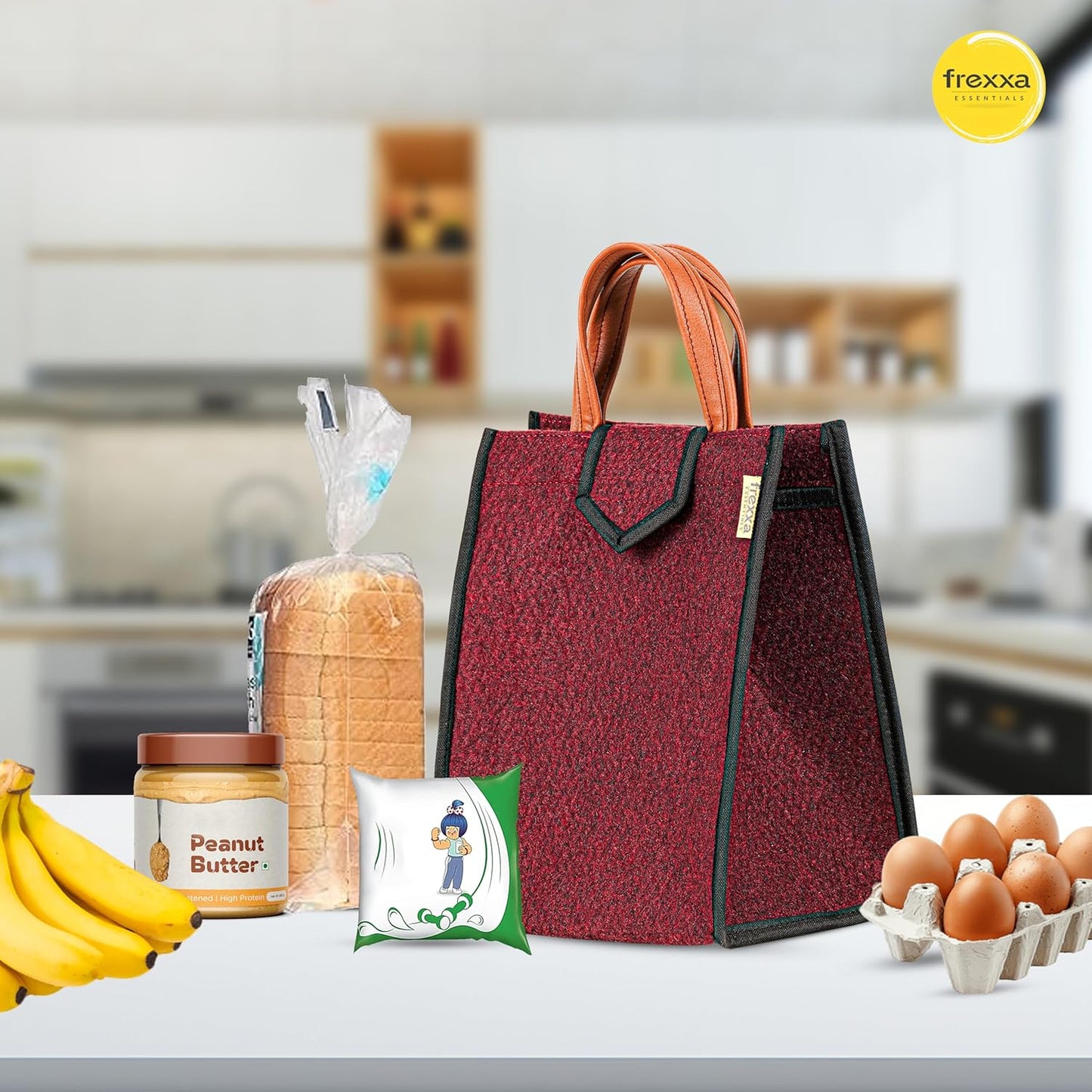 Red reusable shopping bag with bread, bananas, peanut butter, and eggs on a kitchen counter with frexza logo.