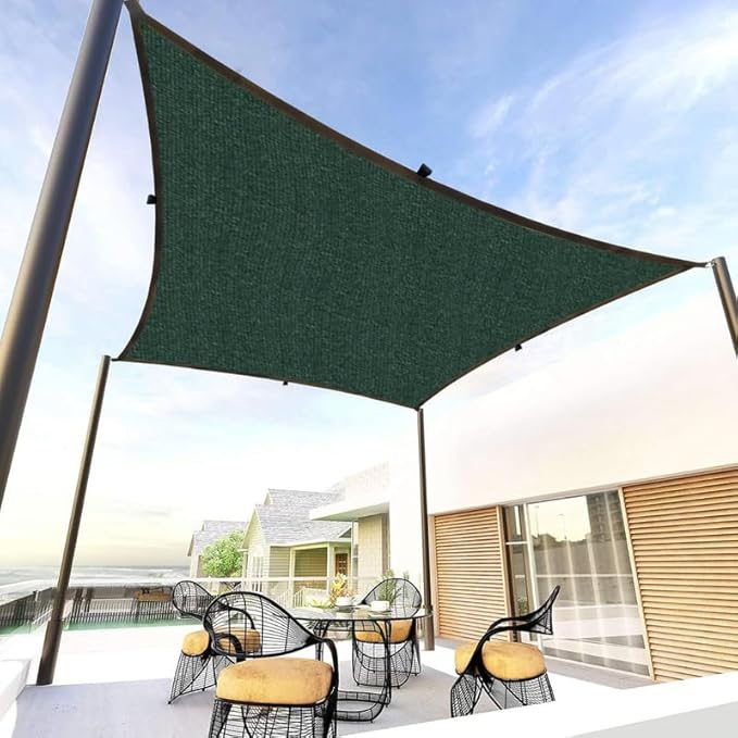 Green outdoor canopy providing shade over a patio table and chairs on a sunny day.