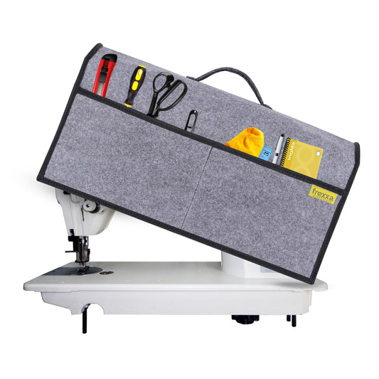 Sewing machine with a gray extension table and various tools on a white background