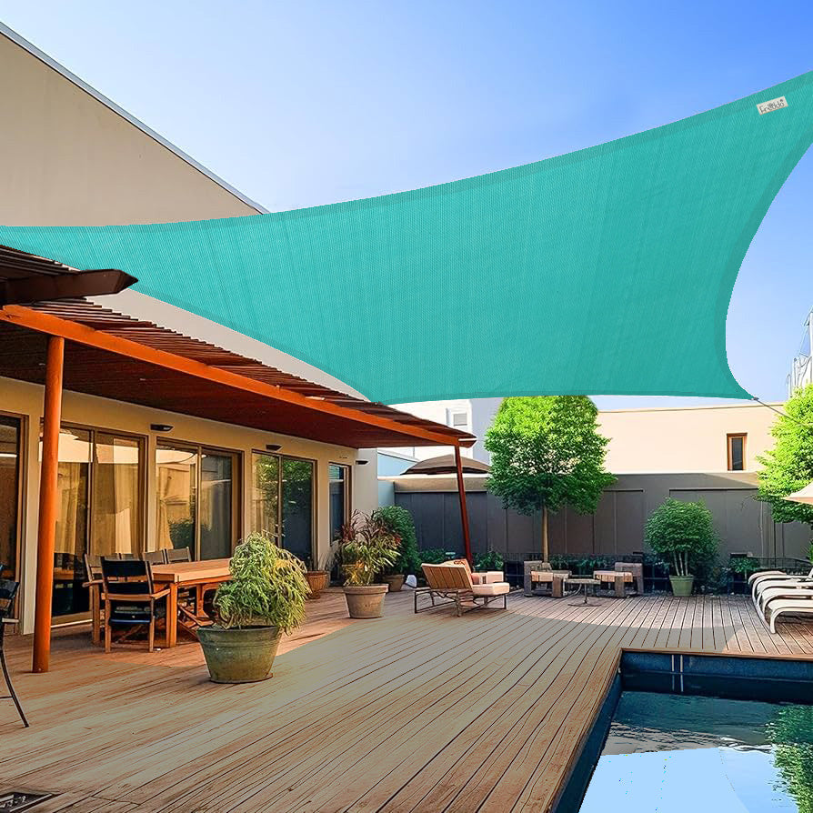 Outdoor patio area with a large turquoise shade sail, wooden deck, and pool.