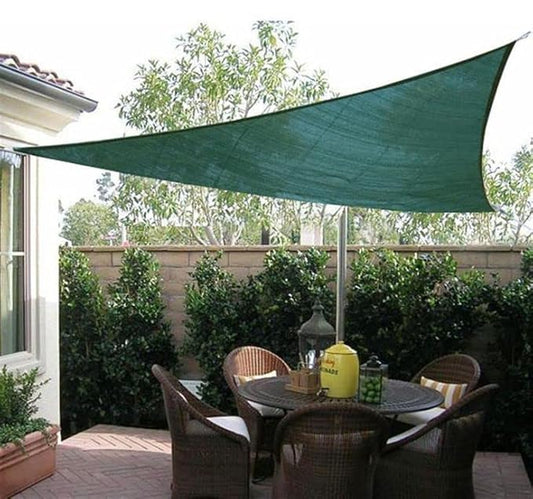 Green triangular patio shade sail over a dining area with chairs and a table.