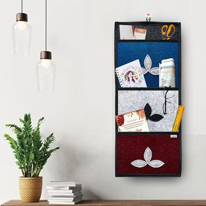 Wall-mounted organizer with compartments holding various items next to a plant and books on a shelf.