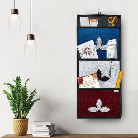 Wall-mounted organizer with compartments holding various items next to a plant and books on a shelf.
